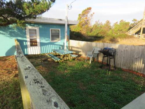 Fenced in yard, picnic table, and charcoal grill 