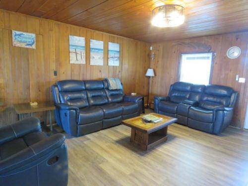 The living room has all leather, reclining furniture 